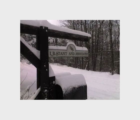 A snow covered road with a sign on it